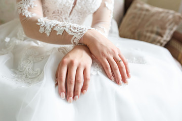 women's hands folded on their knees in anticipation of the wedding and the groom