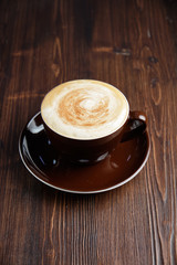 Cappuccino on a brown wooden background. Menu