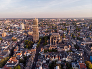 Fototapeta premium Aerial view of the medieval Dutch city centre of Utrecht with the wrapped church tower of the cathedral towering over the city at early morning sunrise