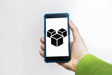 AR Augmented Reality Smartphone App Technology. Hand holds mobile phone with 3d cubes icon.