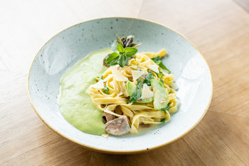 Italian pasta tagliatelle with zucchini, Turkey and green sauce. Parmesan cheese