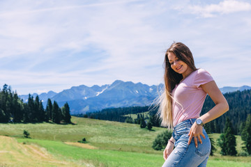 girl with long hair cute smiles on the background of meadows, fo