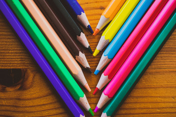 Colors Sharpened Pencils in a diagonal row, close up isolated on a wooden background.