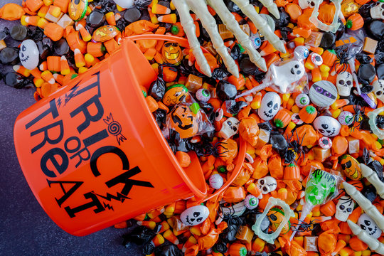Halloween candy spilling out of orange trick or treat bucket