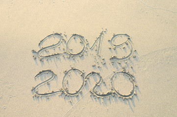 the inscription on the sand 2019 and 2020. new year concept