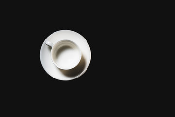 Empty white espresso cup on black background. Coffee cup top view