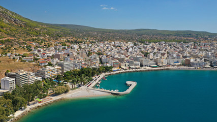 Obraz premium Aerial drone photo of famous seaside area and main town of Loutraki with sandy organised beach with turquoise clear sea and resorts, Greece