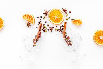 New Year beverage. Ingredients for mulled wine in glasses on white background top view copy space