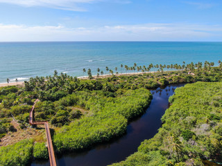 Fototapeta na wymiar Aerial view of river with wood bridge next the tropical beach