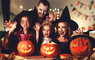 happy family mother father and children in costumes and makeup on  Halloween.