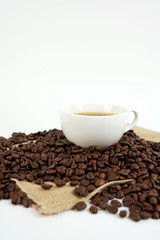 brown roasted coffee beans and coffee cup