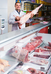 Butcher cutting fresh lamb meat