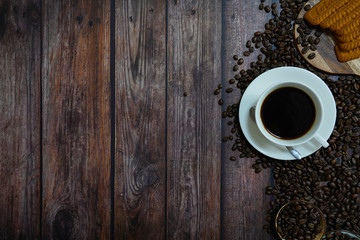 brown roasted coffee beans and coffee cup