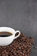 brown roasted coffee beans and coffee cup