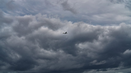 Little airplane against the stormy sky over pacific ocean