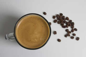 cup of coffee on white table and coffee beans