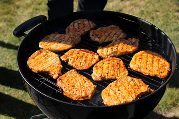beautiful grilled roast meat grilled on the street on a black metal grill on burning coals, picnic concept, close-up