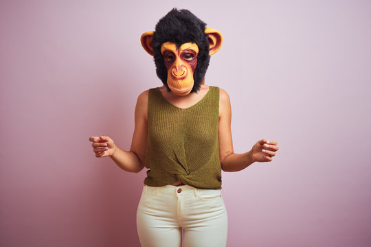 Woman standing wearing t-shirt and monkey mask