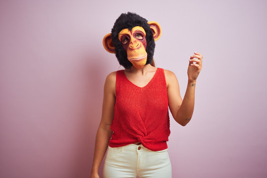 Woman standing wearing t-shirt and monkey mask