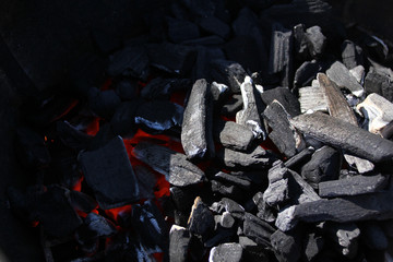 smoldering and burning coals in a round barbecue grill