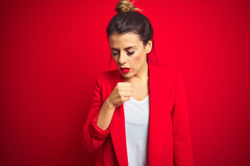 Young beautiful business woman standing over red isolated background feeling unwell and coughing as symptom for cold or bronchitis. Healthcare concept.