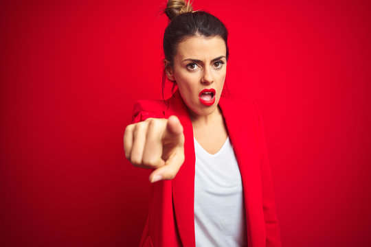 Young beautiful business woman standing over red isolated background pointing displeased and frustrated to the camera, angry and furious with you