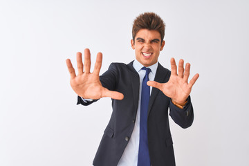 Young handsome businessman wearing suit standing over isolated white background afraid and terrified with fear expression stop gesture with hands, shouting in shock. Panic concept.