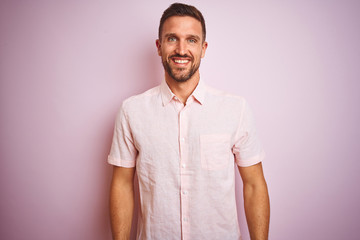 Young handsome man wearing elegant summer shirt over pink isolated background with a happy and cool smile on face. Lucky person.