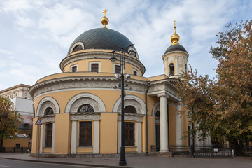 Fototapeta na wymiar Orthodox church in the center of Moscow with an unusual pattern of facade elements. In the foreground is a street lamp
