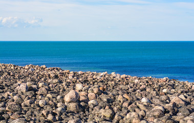 Just rocks and a calm sea. Round stones washed by the waters of the Arctic ocean. The deep blue color of the sea inspires, sets up a romantic mood. Barents sea, near Teriberka, Murmansk oblast