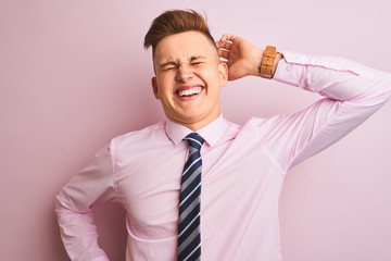 Young handsome businessman wearing shirt and tie standing over isolated pink background stretching back, tired and relaxed, sleepy and yawning for early morning