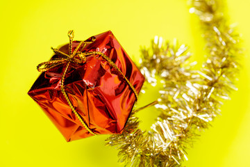 Tinsel Garland isolated on bright yellow background. Christmas gift decoration. Winter Holidays concept.