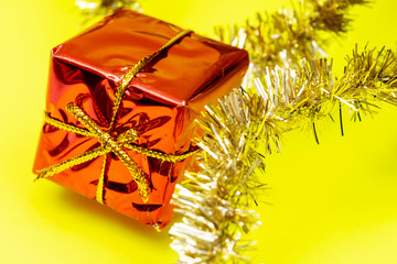 Tinsel Garland isolated on bright yellow background. Christmas gift decoration. Winter Holidays concept.