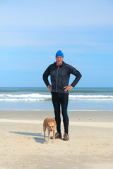 Senior man sporting with dog at beach