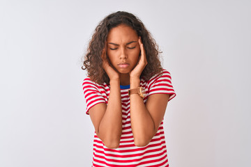 Young brazilian woman wearing red striped t-shirt standing over isolated white background with hand on headache because stress. Suffering migraine.