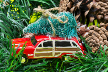 Christmas Tree on a toy car on bright yellow background. Winter Holidays celebration concept.