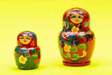 Colorful Nesting wooden Dolls isolated on bright yellow background. National Russian souvenirs....