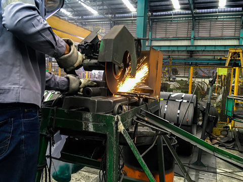 Man is using electricity saw in factory, Falsh fire from elctric saw, Metal cutting operation, Worker work in construction site, steel structures manufacture works
