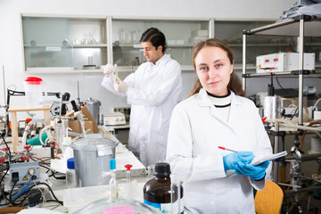 Obraz premium Female chemist writing results of experiments