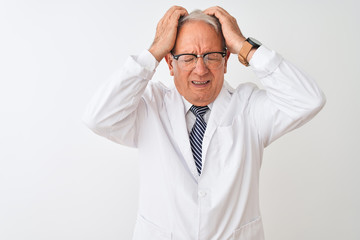 Senior grey-haired scientist man wearing coat standing over isolated white background suffering from headache desperate and stressed because pain and migraine. Hands on head.