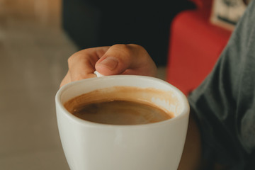 White hot cup of coffee in the cafe. Concept of aroma and relax.