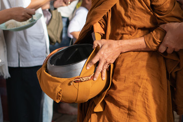 on buddhist holy day Thai buddhist people always go to temple to offer food to monks