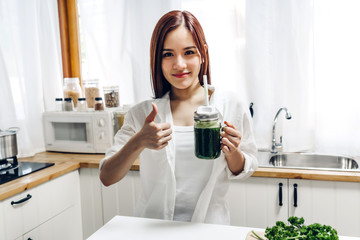 Healthy woman enjoy making green vegetables detox cleanse and green fruit smoothie with blender in kitchen at home.dieting concept.healthy lifestyle