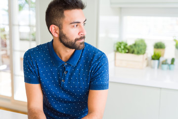 Fototapeta premium Handsome hispanic man at home looking to side, relax profile pose with natural face with confident smile.