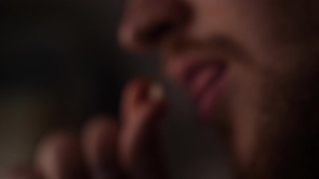 Young bearded man taking a medicine drug pill tablet for pain killer headache 