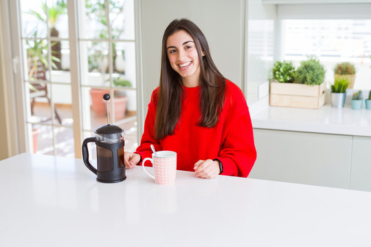 Young beautiful woman making morning coffee smiling, preparing a cup of latte for breakfast