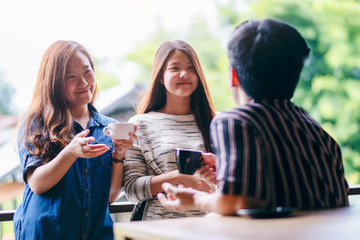 Closeup image of three people enjoyed talking and drinking coffee together in cafe