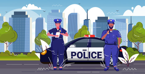 policeman using walkie-talkie policewoman writing fine report mix race police officers standing near patrol car road traffic safety regulations concept cityscape background sketch horizontal © mast3r