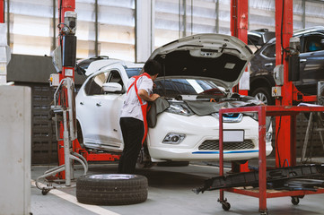 mechanic working car maintenance with soft-focus and over light in the background