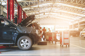 mechanic working car maintenance with soft-focus and over light in the background